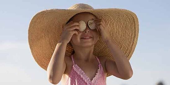 Chica con sombrero y traje de baño al sol