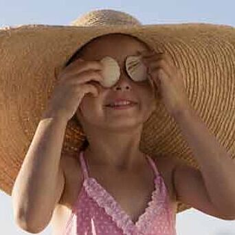 Chica con sombrero y traje de baño al sol