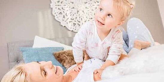 mamá y niño en la cama con almohada azul