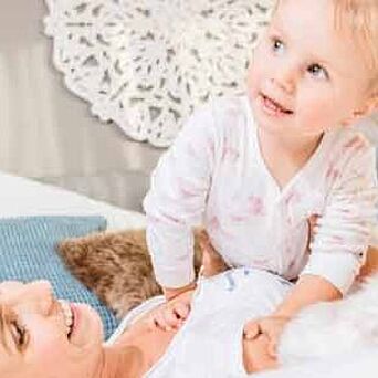 mamá y niño en la cama con almohada azul