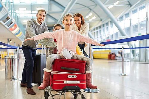 Equipaje probado para calidad y seguridad Familia empujando equipaje en un aeropuerto