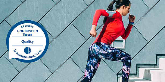 Mujer corriendo con ropa deportiva y Sello de Calidad Hohenstein
