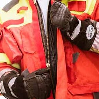 Bombero con guantes protectores y chaqueta desabrochada