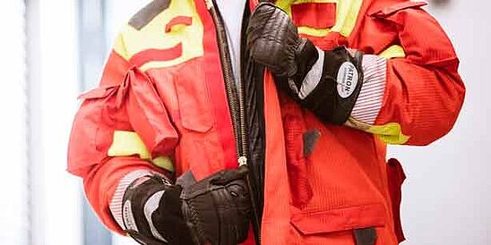 Bombero con guantes protectores y chaqueta desabrochada