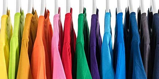 camisas de muchos colores colgando de un estante