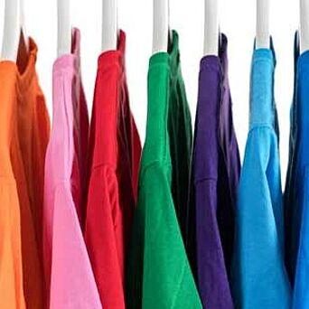 camisas de muchos colores colgando de un estante