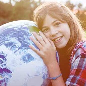 Joven sosteniendo un globo terráqueo.