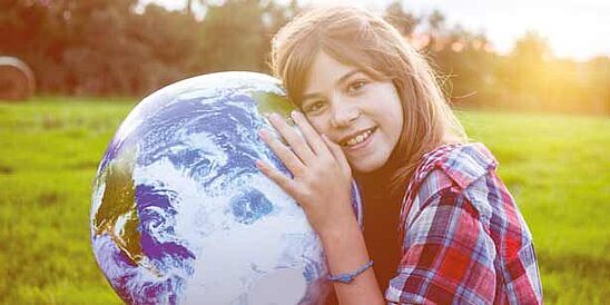 Joven sosteniendo un globo terráqueo.