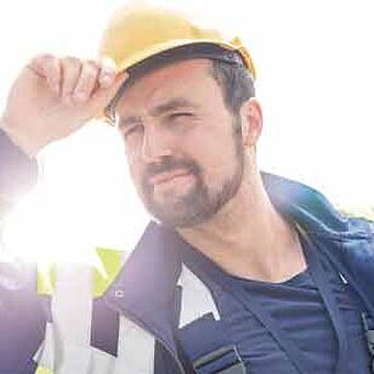 Trabajador con casco y equipo de protección en un día soleado