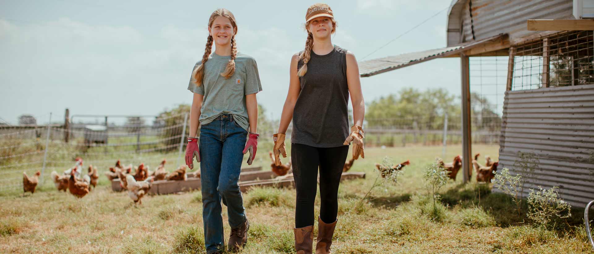 Dos mujeres en ropa de trabajo de Carhartt en una granja