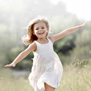 Niña de vestido blanco corriendo fuera