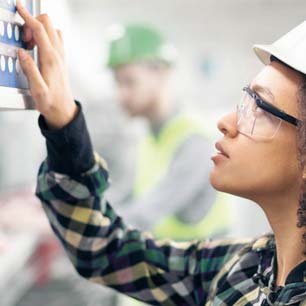 Trabajador textil con gafas en seguridad y casco.