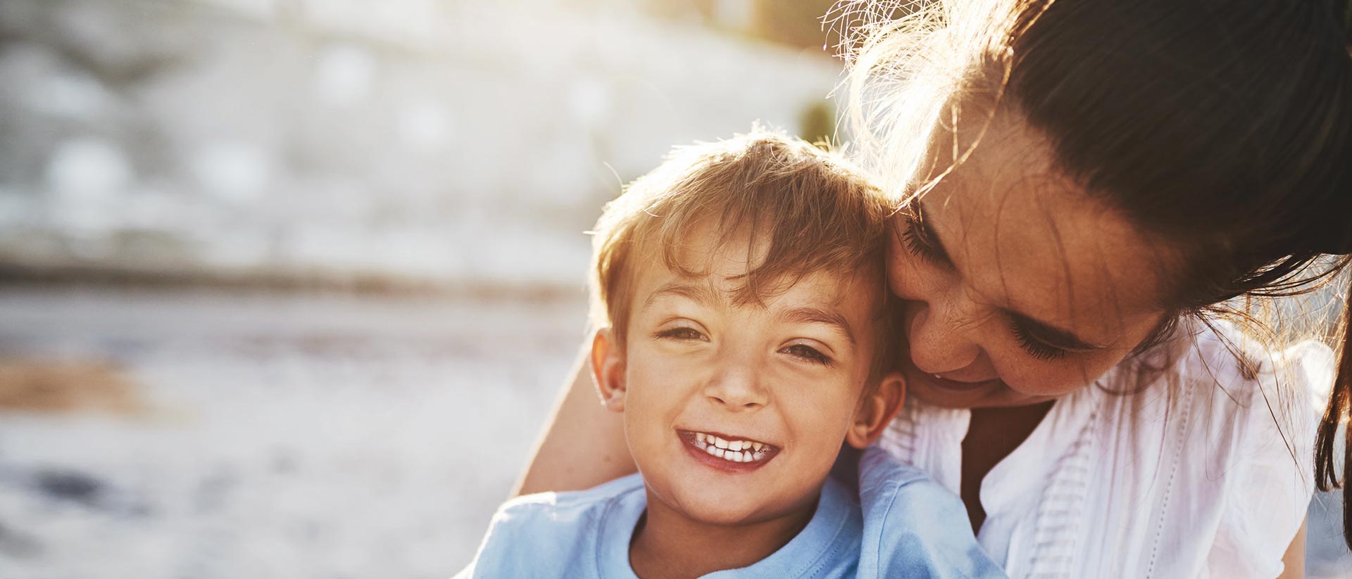 Mamá e hijo riendo juntos afuera