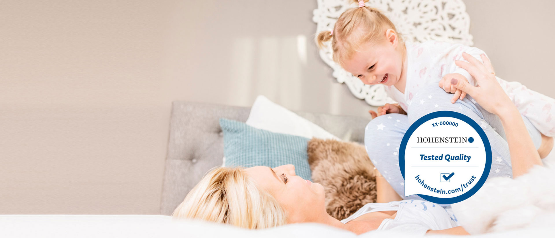 Mamá y niño jugando en la cama, Sello de Calidad Hohenstein