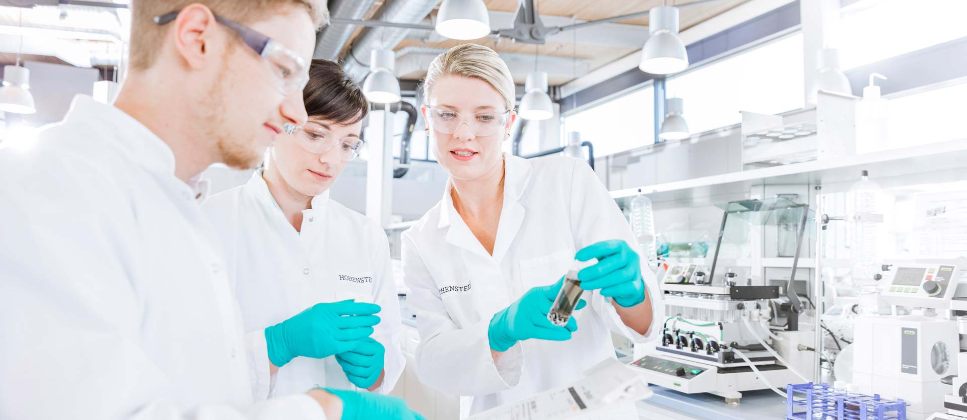 3 técnicos de laboratorio de Hohenstein analizando una muestra de prueba en el laboratorio