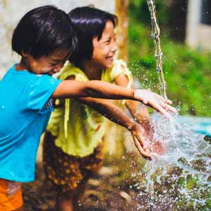 Dos niños chapoteando en agua limpia