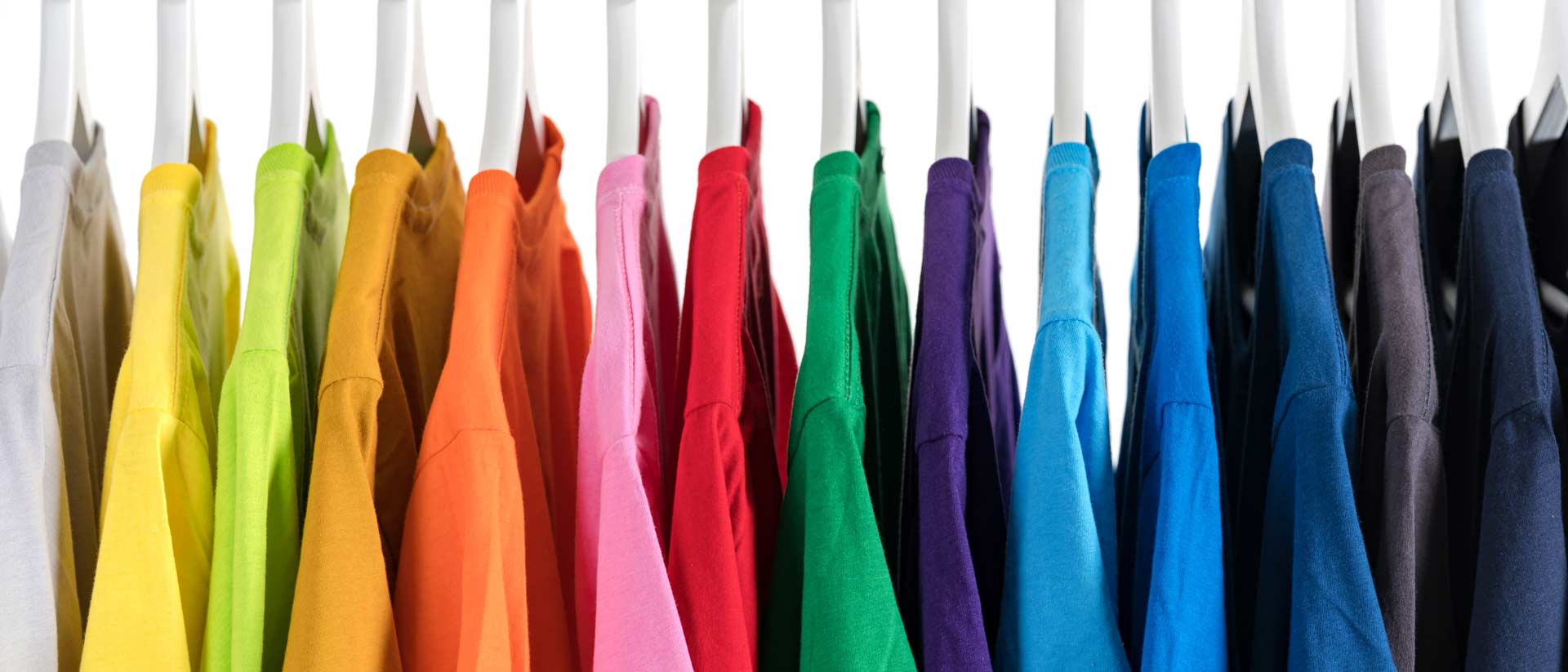 camisas de varios colores colgando de un estante