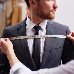 Ingeniero de ropa midiendo el pecho de un hombre