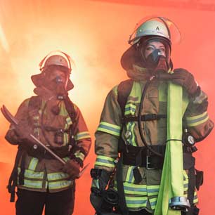 2 firefighters in turnout gear and helmets