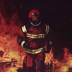 Bombero con casco y saliendo de un incendio.