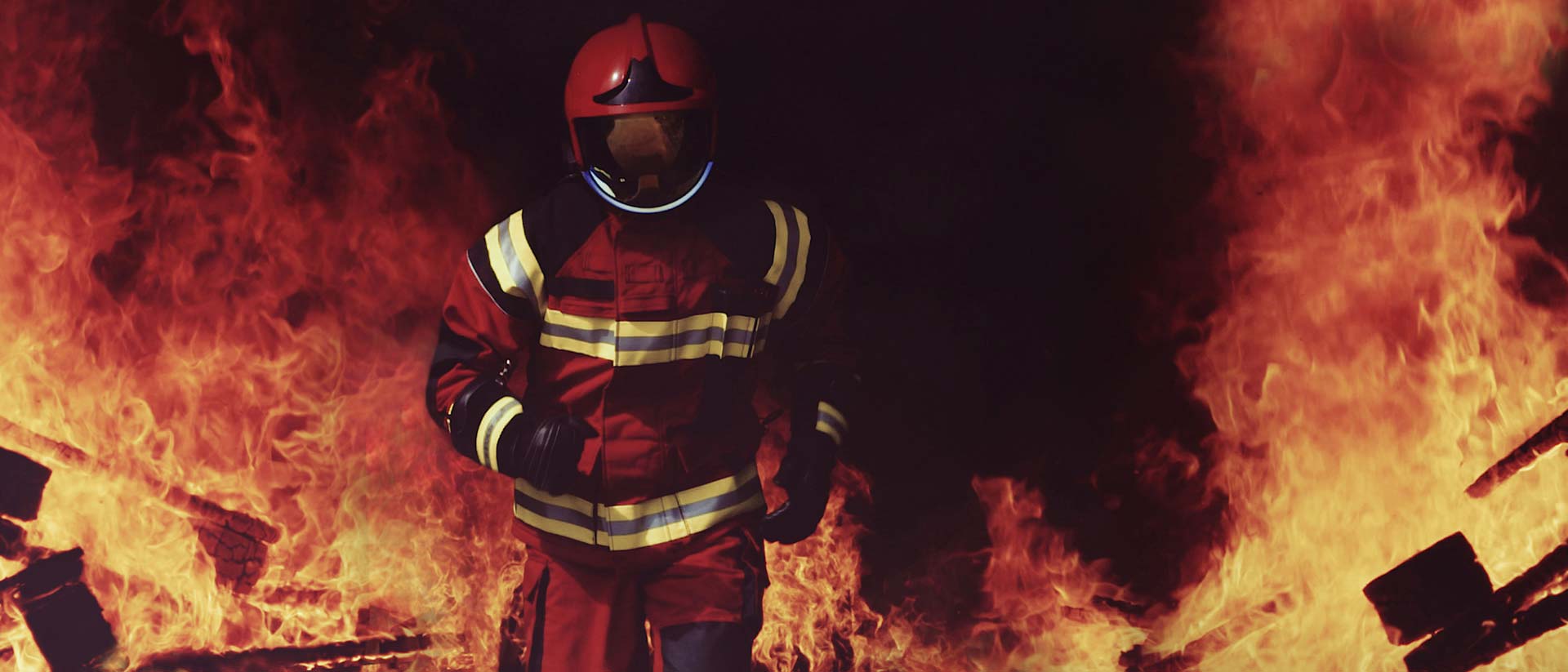 Bombero con casco y saliendo de un incendio.